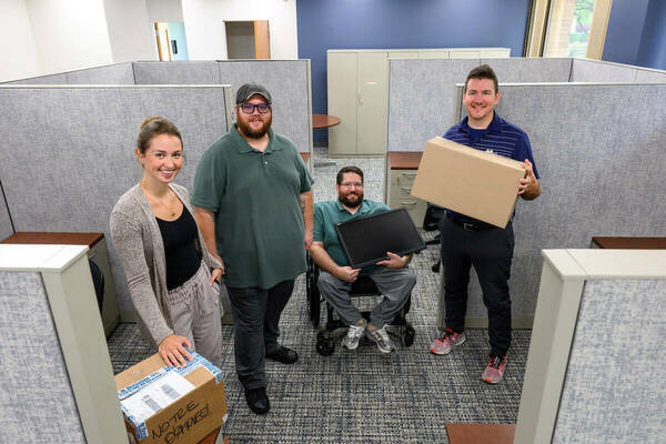 Left to right: Hannah Davis of Human Resources, Stephen Weaver of the Irish1 Card office, Ben Lawecki from Parking Services and Mike Hovestol from Irish1 Card pose for a photo in the new office space on the first floor of Grace Hall, in the space formerly occupied by Cafe De Grasta. (Photo by Matt Cashore/University of Notre Dame)