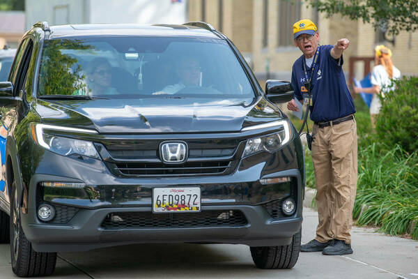 A volunteer gives directions on move-in day of Welcome Weekend 2023.